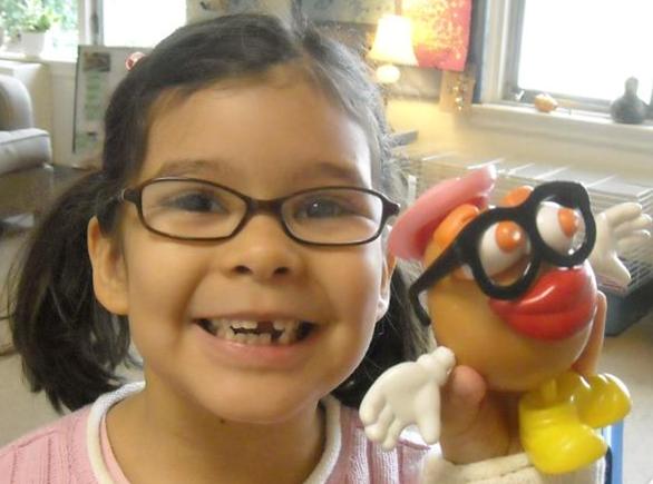 A child showing off her Mr. Potato Head toy