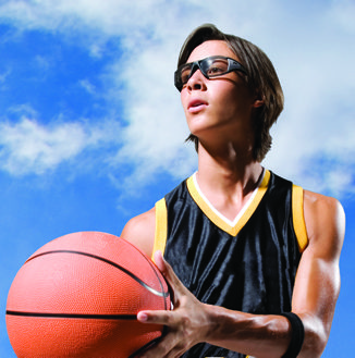 A photo of a kid holding a basketball and wearing sports glasses