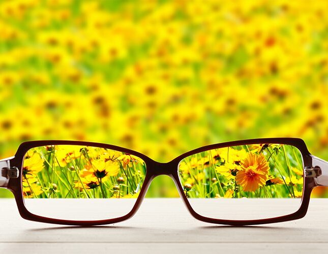 An image displaying glasses sitting on a table providing focus to a blurry world