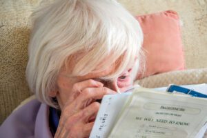 woman using magnifying loupe to read