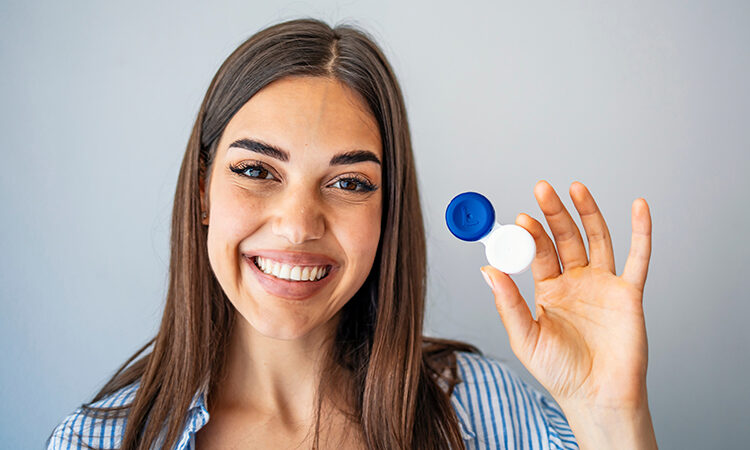 a woman holding a contact lens case: proper handling of contact lenses can prevent acanthamoeba keratitis infection