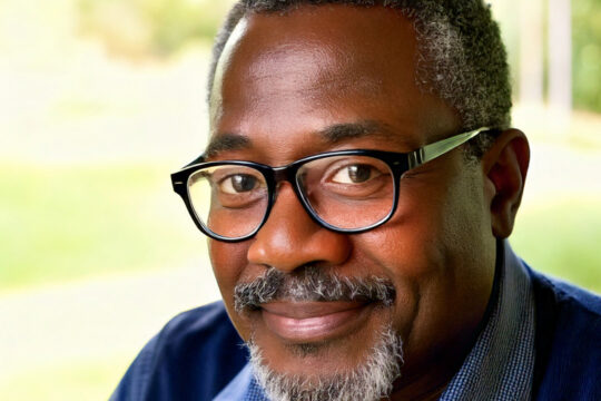 a middle-aged man wearing glasses.