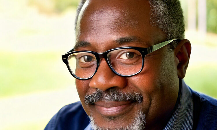 a middle-aged man wearing glasses.