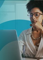 a woman wearing glasses, looking at a computer screen